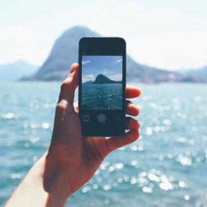 Smart phone camera taking a picture of the ocean.